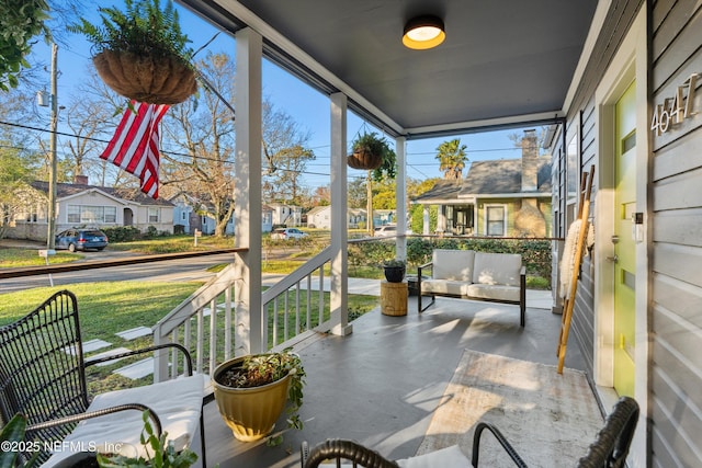 balcony featuring outdoor lounge area, covered porch, and a residential view