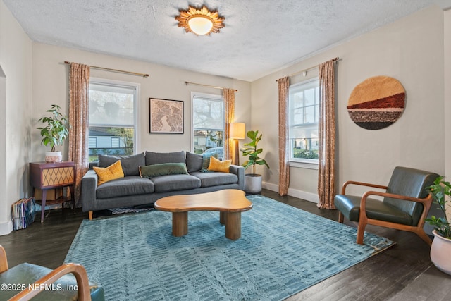 living area with dark wood finished floors, baseboards, and a textured ceiling