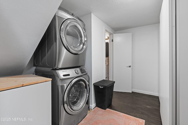 clothes washing area with laundry area, stacked washing maching and dryer, baseboards, and wood finished floors