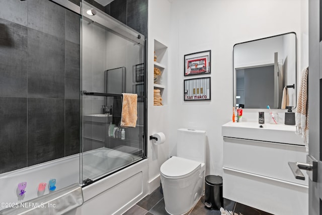 full bath featuring bath / shower combo with glass door, vanity, and toilet