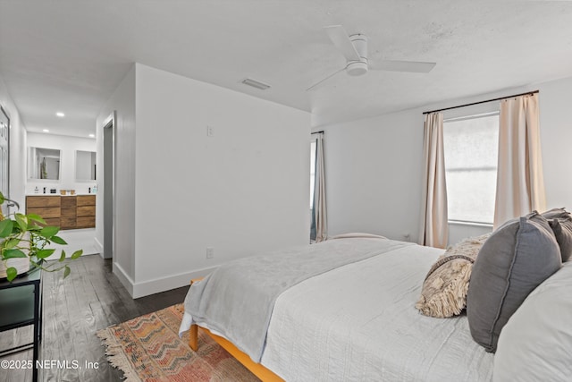 bedroom with visible vents, baseboards, ensuite bathroom, wood finished floors, and a ceiling fan