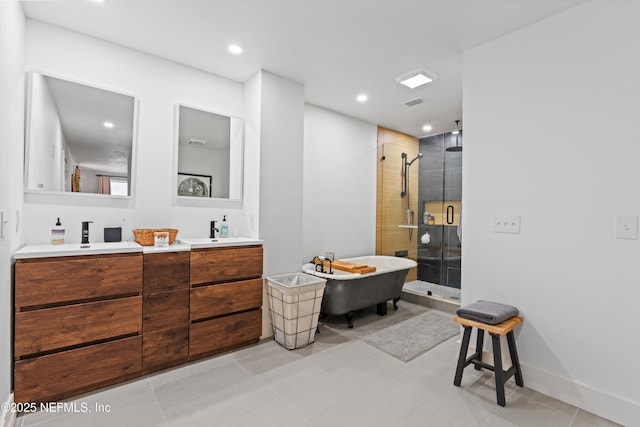 bathroom with a shower stall, a freestanding tub, double vanity, and a sink