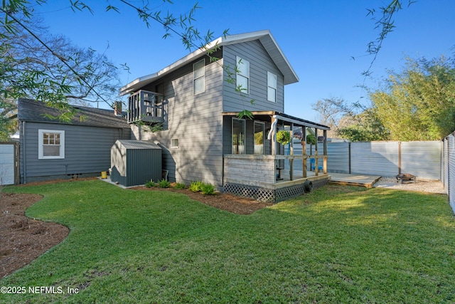 rear view of property with a storage shed, a yard, an outbuilding, and a fenced backyard