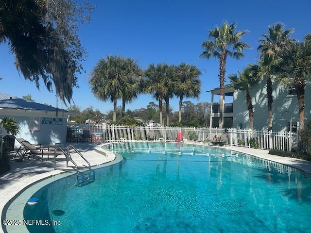 pool with a patio area and fence