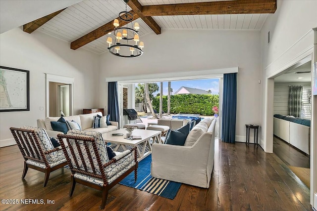 living area featuring wood finished floors, baseboards, high vaulted ceiling, beam ceiling, and a notable chandelier