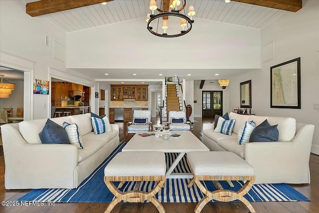 living area with beamed ceiling, a notable chandelier, and high vaulted ceiling