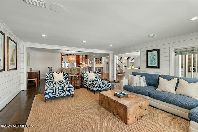 living room with recessed lighting, wood finished floors, visible vents, and ornamental molding