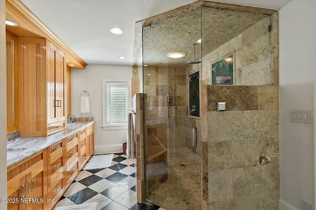 bathroom with baseboards, double vanity, recessed lighting, a stall shower, and a sink