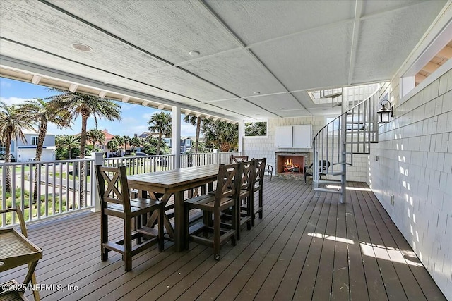 wooden deck with outdoor dining space and stairway