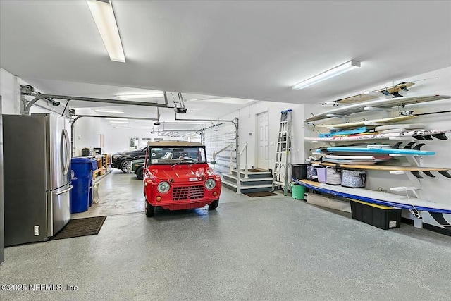 garage featuring a garage door opener and freestanding refrigerator