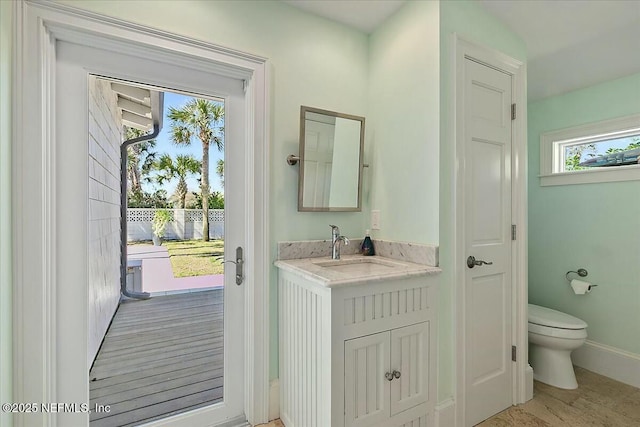 bathroom featuring vanity, toilet, and baseboards