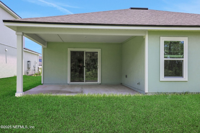 251 Pinzon Pl, Saint Augustine, FL 32095 - rear view of house featuring roof with shingles, a lawn, a patio, and stucco siding
