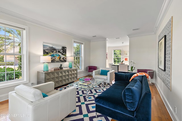 living room featuring baseboards, wood finished floors, visible vents, and ornamental molding