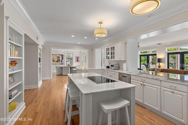 kitchen with a kitchen island, a peninsula, ornamental molding, a sink, and stainless steel dishwasher