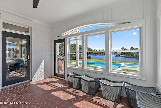 sunroom / solarium featuring a wealth of natural light and a water view