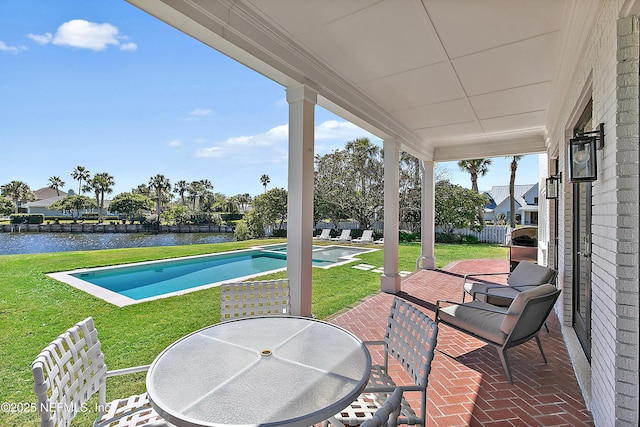 view of patio featuring an outdoor pool, outdoor dining area, and a water view