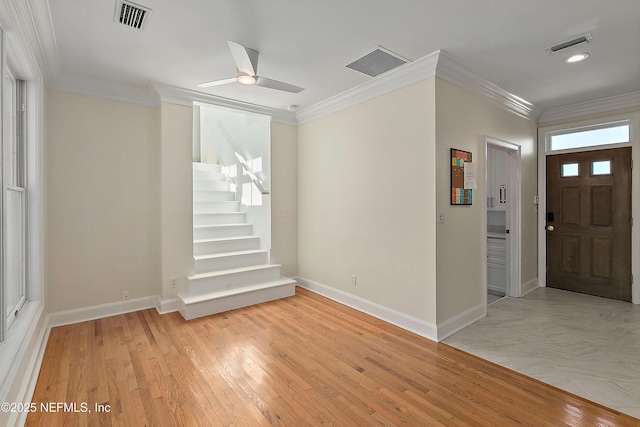 foyer entrance featuring a ceiling fan, crown molding, light wood-style floors, and visible vents