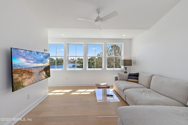 living room featuring baseboards, recessed lighting, a ceiling fan, and light wood-style floors