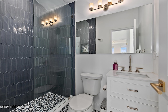 bathroom featuring vanity, toilet, and tiled shower