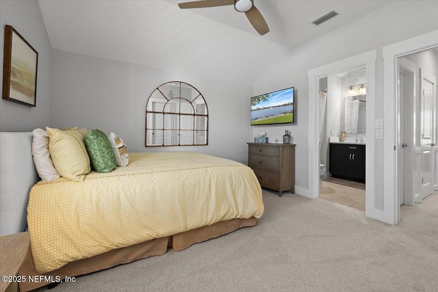 bedroom featuring visible vents, connected bathroom, light colored carpet, vaulted ceiling, and a ceiling fan