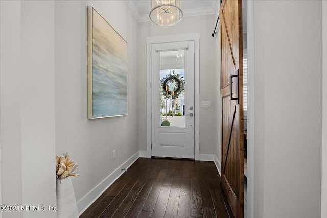 doorway to outside with a barn door, baseboards, ornamental molding, and dark wood-style flooring