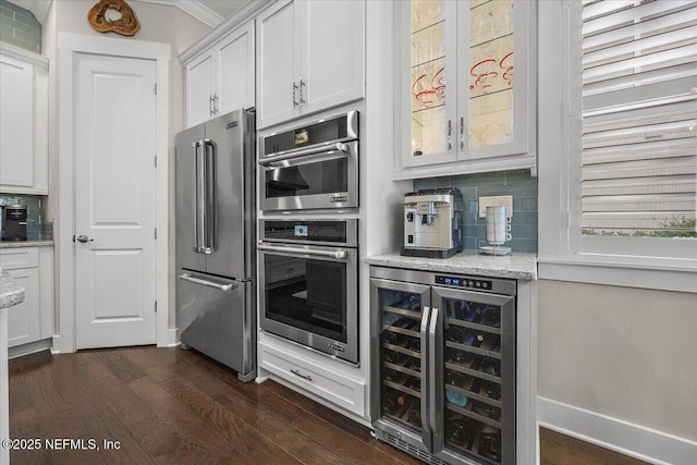 kitchen featuring tasteful backsplash, white cabinetry, wine cooler, appliances with stainless steel finishes, and dark wood-style flooring