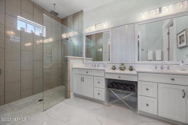 bathroom featuring marble finish floor, a shower stall, and a sink