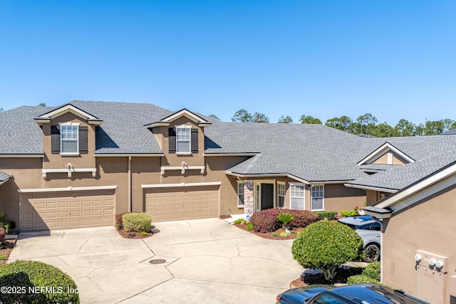 view of front facade featuring stucco siding, a garage, roof with shingles, and driveway