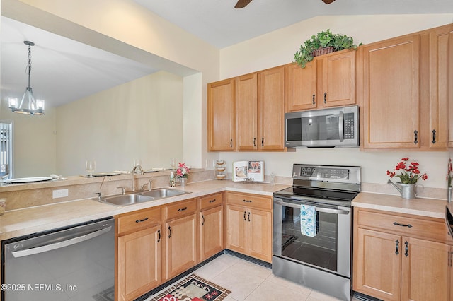 kitchen with a sink, stainless steel appliances, light tile patterned flooring, and light countertops