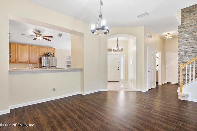 interior space with visible vents, arched walkways, dark wood-type flooring, and ceiling fan with notable chandelier