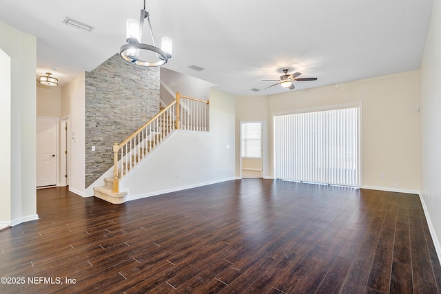 unfurnished living room featuring stairway, dark wood-type flooring, visible vents, and a ceiling fan