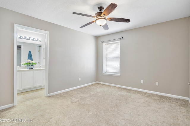 unfurnished room with light carpet, baseboards, a textured ceiling, and ceiling fan