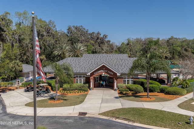 view of front facade featuring a front lawn, brick siding, and driveway