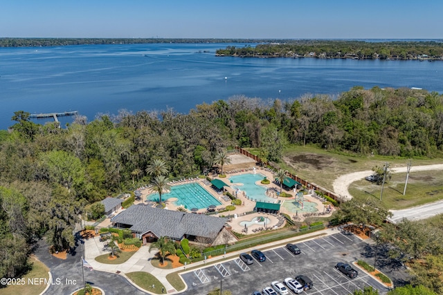 drone / aerial view featuring a water view and a wooded view