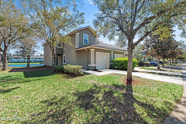 traditional home featuring concrete driveway, a front yard, and stucco siding