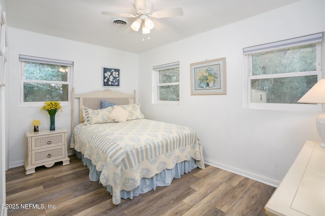 bedroom with visible vents, multiple windows, baseboards, and wood finished floors