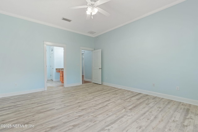 unfurnished room featuring visible vents, baseboards, light wood-style flooring, and crown molding