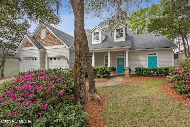 view of front of property with a garage and roof with shingles