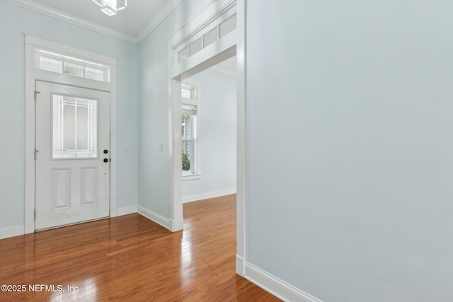 entryway with baseboards, wood-type flooring, and ornamental molding