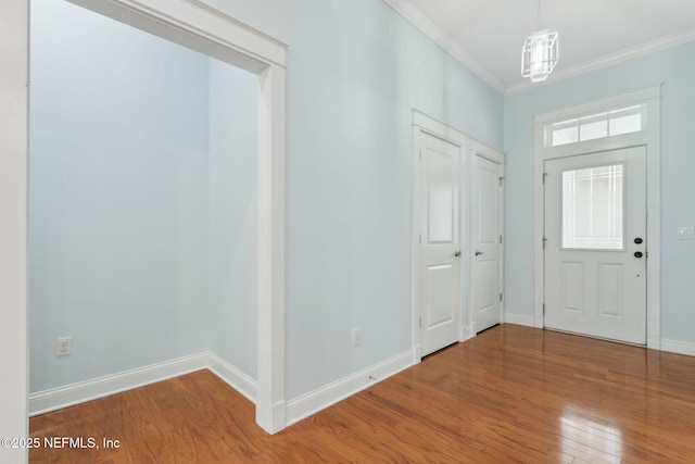 foyer entrance with ornamental molding, baseboards, and hardwood / wood-style floors