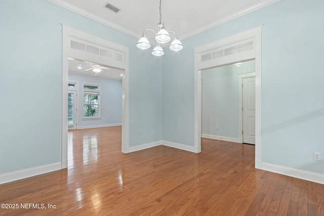 unfurnished room with visible vents, crown molding, baseboards, and wood-type flooring