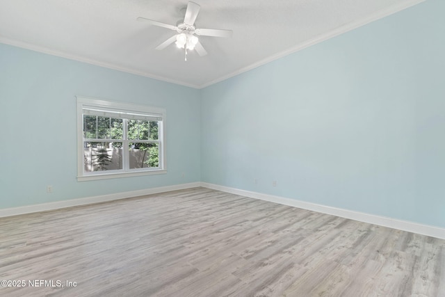 spare room featuring light wood-style flooring, crown molding, and baseboards