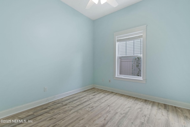 empty room with baseboards, wood finished floors, and a ceiling fan