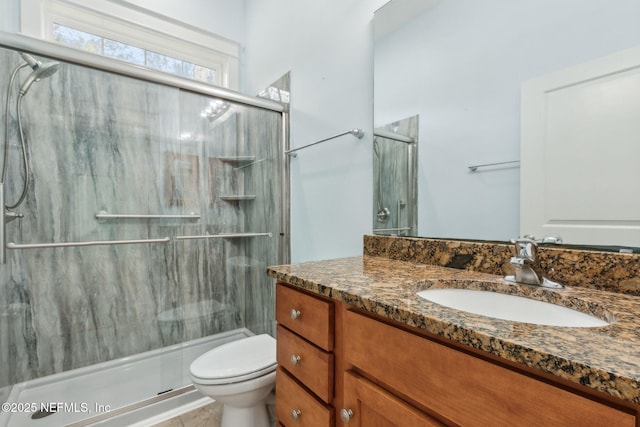 full bathroom featuring tile patterned flooring, vanity, a shower stall, and toilet