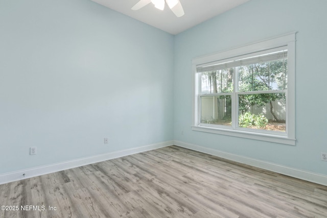 empty room featuring ceiling fan, baseboards, and wood finished floors