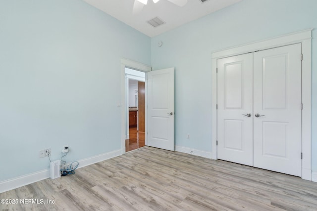 unfurnished bedroom featuring visible vents, baseboards, wood finished floors, a closet, and a ceiling fan