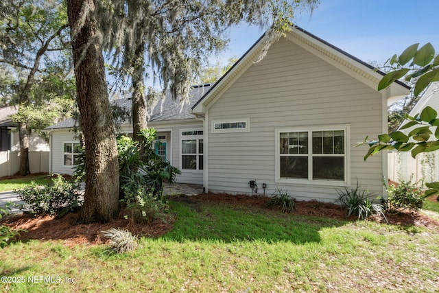 rear view of house featuring a lawn