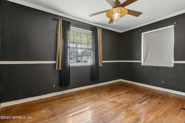 unfurnished room featuring a ceiling fan, wood-type flooring, baseboards, and ornamental molding