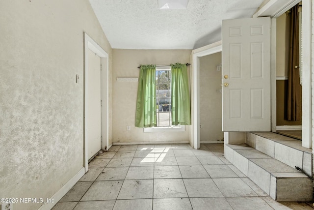 spare room featuring baseboards and a textured ceiling