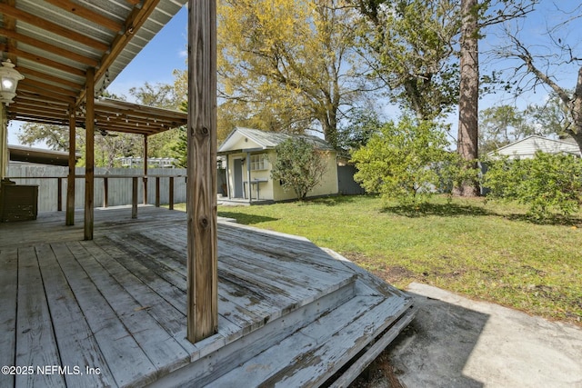 wooden deck featuring an outbuilding and a yard